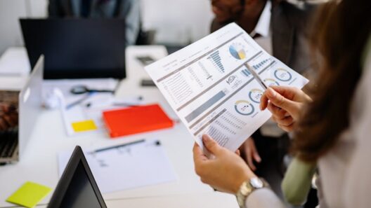 Professionals reviewing business charts and documents in a team meeting.