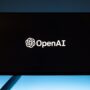 Minimalist display of OpenAI logo on a screen, set against a gradient blue background.