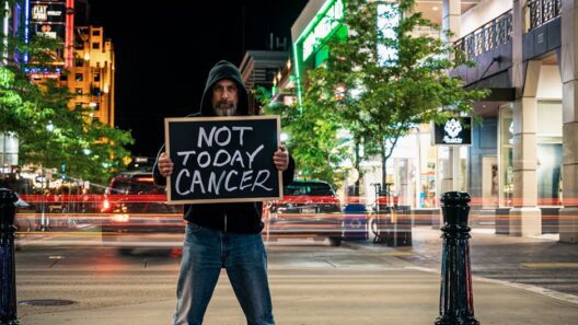 Man holds anti-cancer sign in a busy urban night setting, with light trails and buildings.