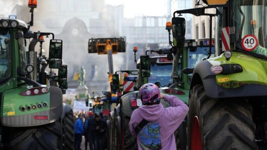 Farmers protest in city street with tractors and people gathered.