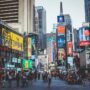 Bustling daytime view of Times Square with crowds, skyscrapers, and iconic billboards in New York City.